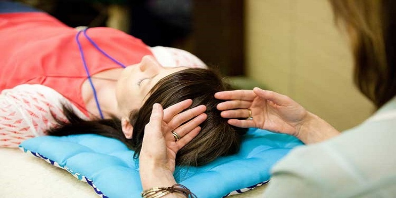 Mujer acostada recibiendo un masaje en la cabeza