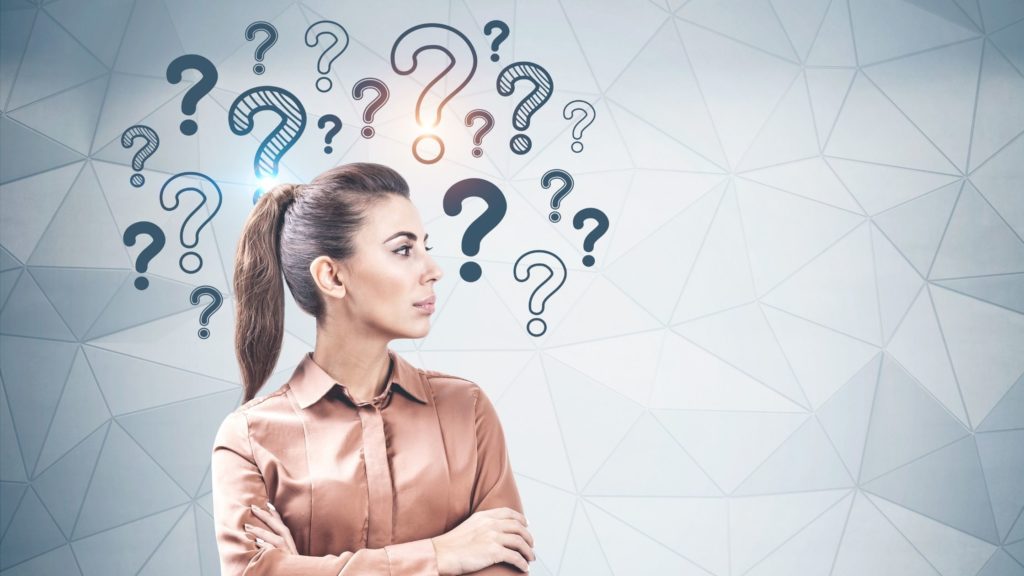 Mujer empresaria con iconos de signo de interrogación al rededor de la cabeza