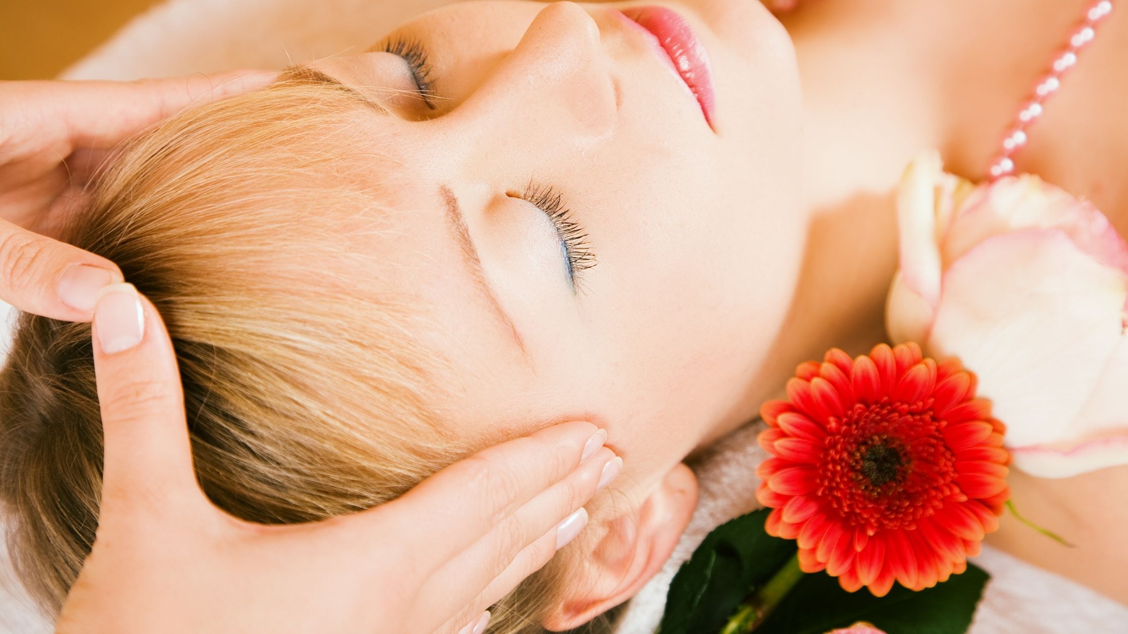 Mujer joven relajada mientras recibe un masaje en la cabeza