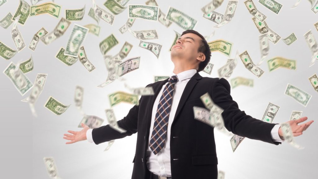 Hombre empresario en medio de una lluvia de dólares